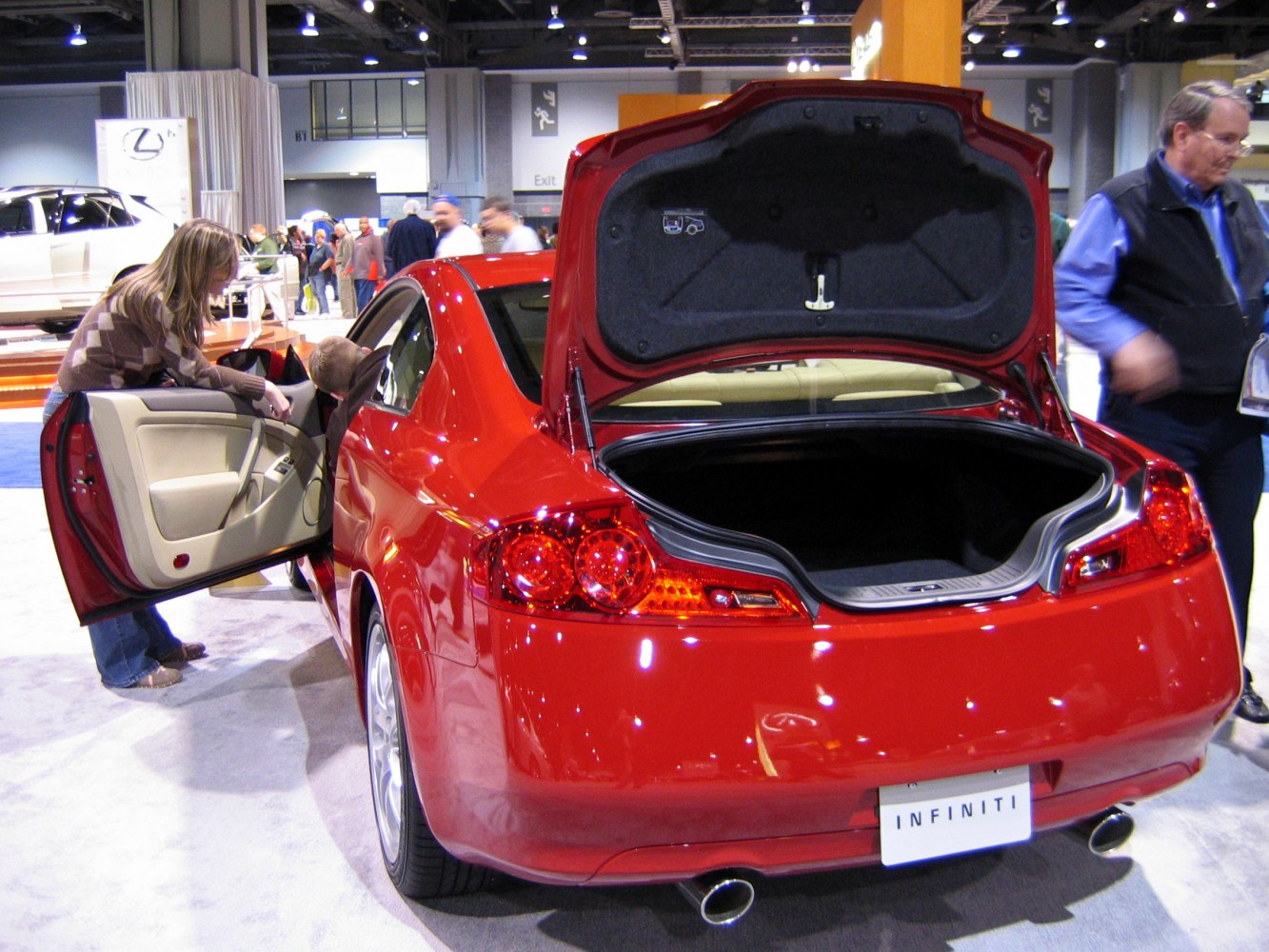 Rear view of red coupe with open trunk and door
