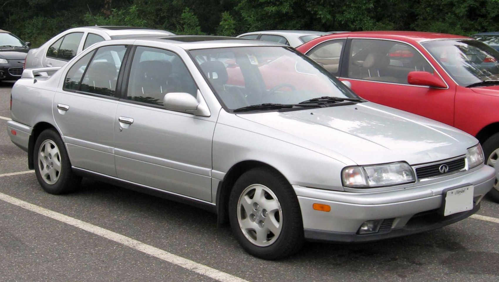 Silver 1990s compact sedan with rear spoiler and alloy wheels