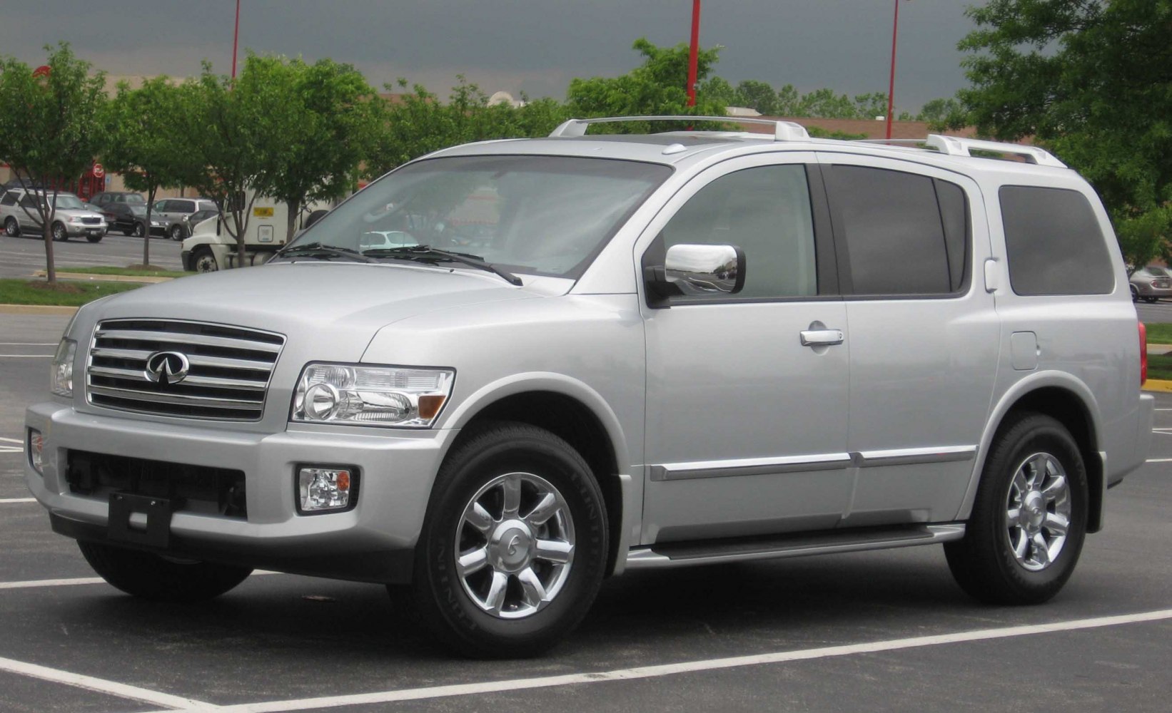 Silver full-size SUV front side with chrome grille and roof rails