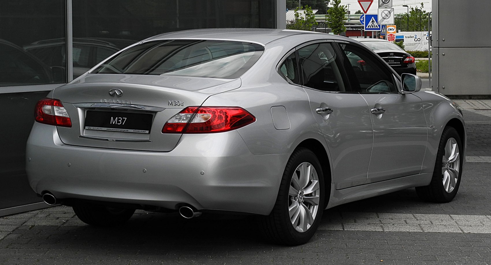 Rear view of mid-2010s sedan with dual exhausts and LED taillights