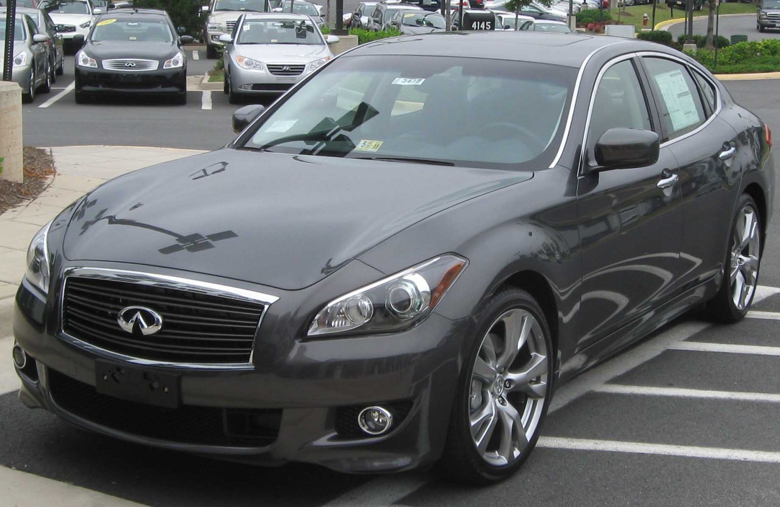 Sporty sedan front 3/4 view with chrome grille and prominent headlights