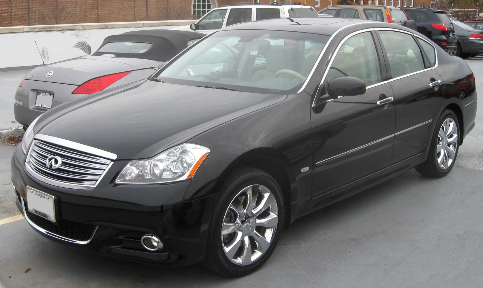 Front side view of a luxury sedan with chrome grille and alloy wheels.