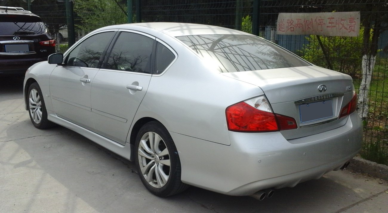 Silver sedan rear view with dual exhaust and stylized taillights