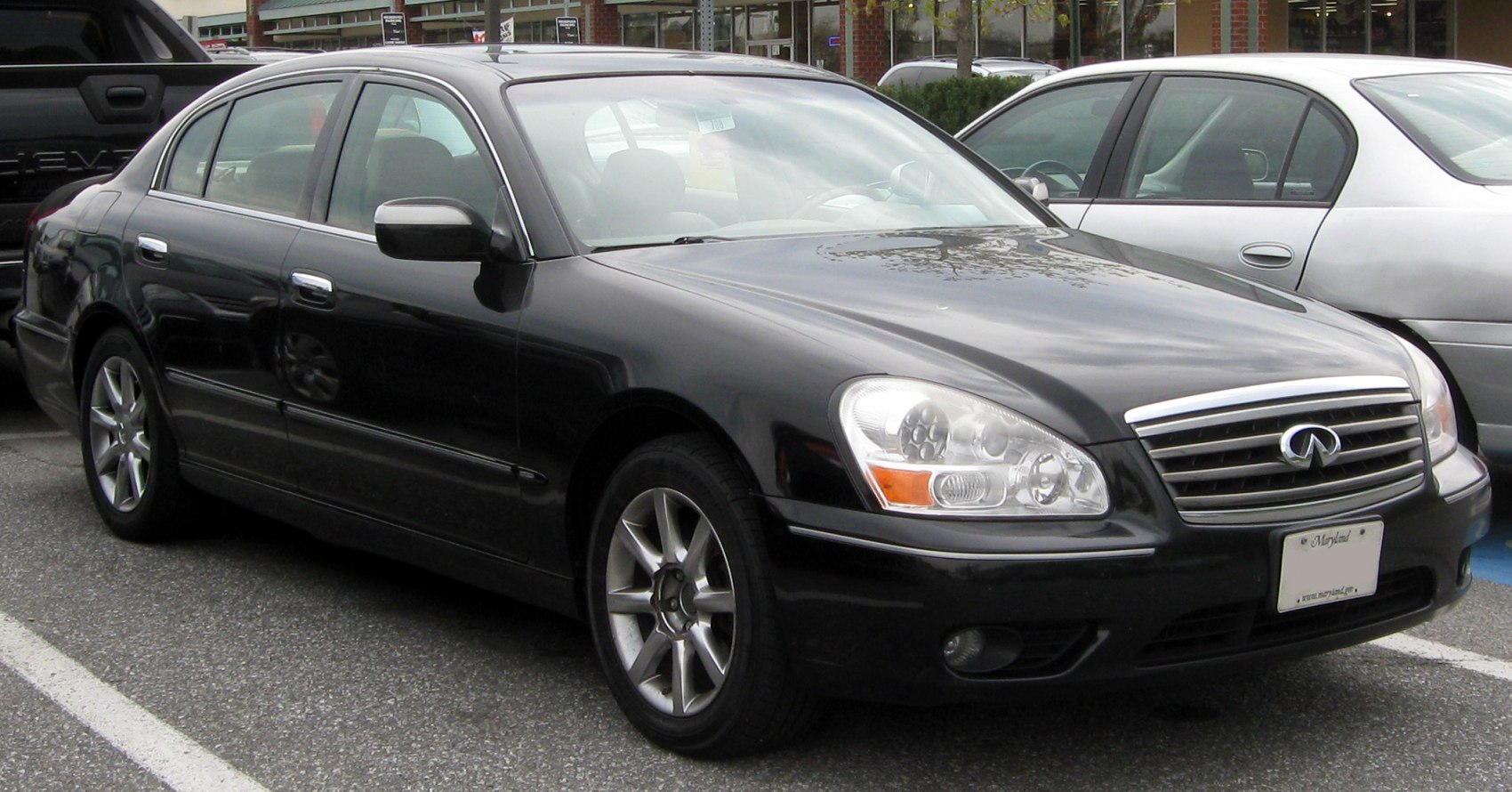 Front side view of a sedan with distinctive headlights and chrome grille