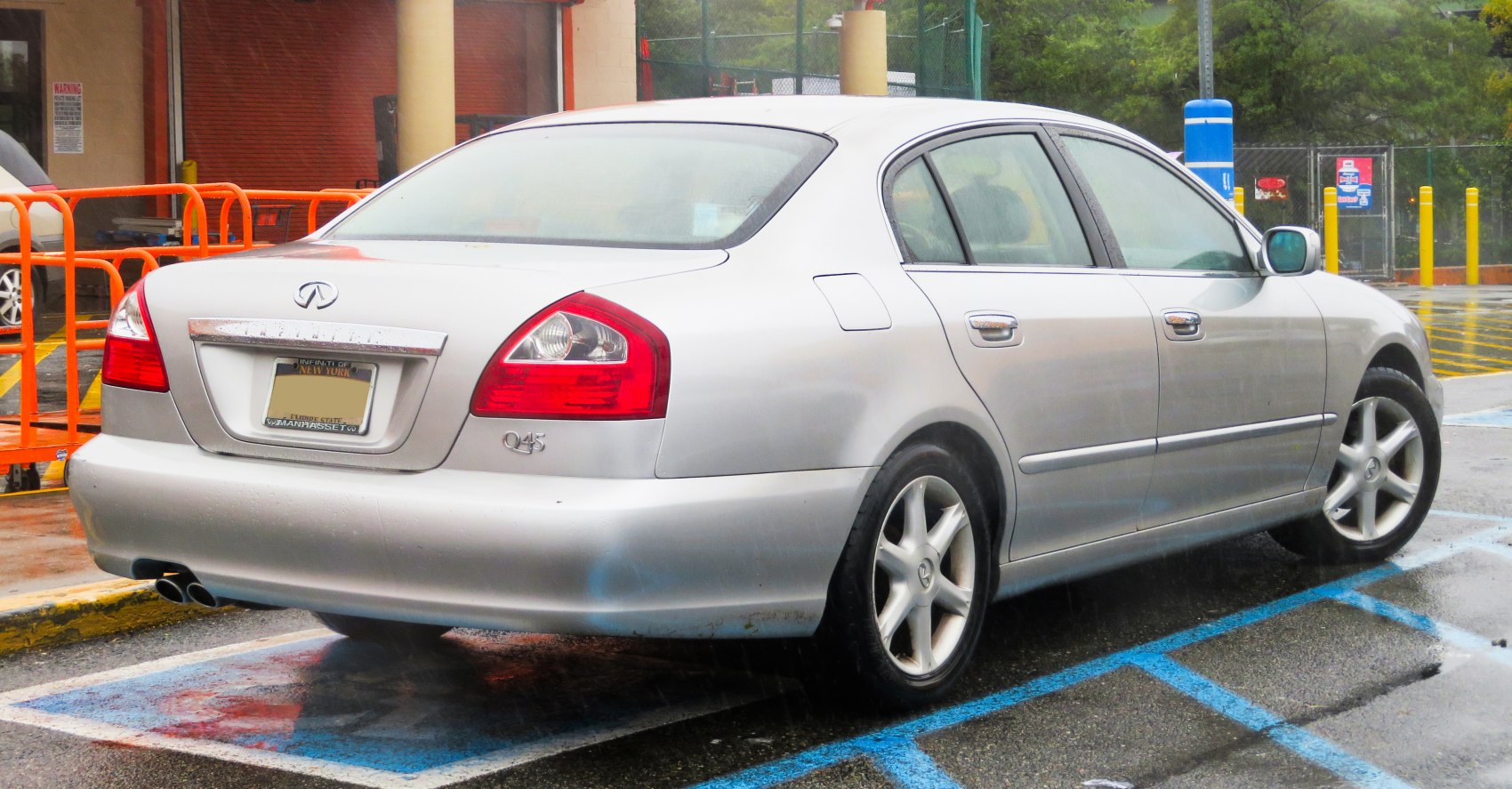 Silver sedan rear side with taillights, dual exhaust, alloy wheels