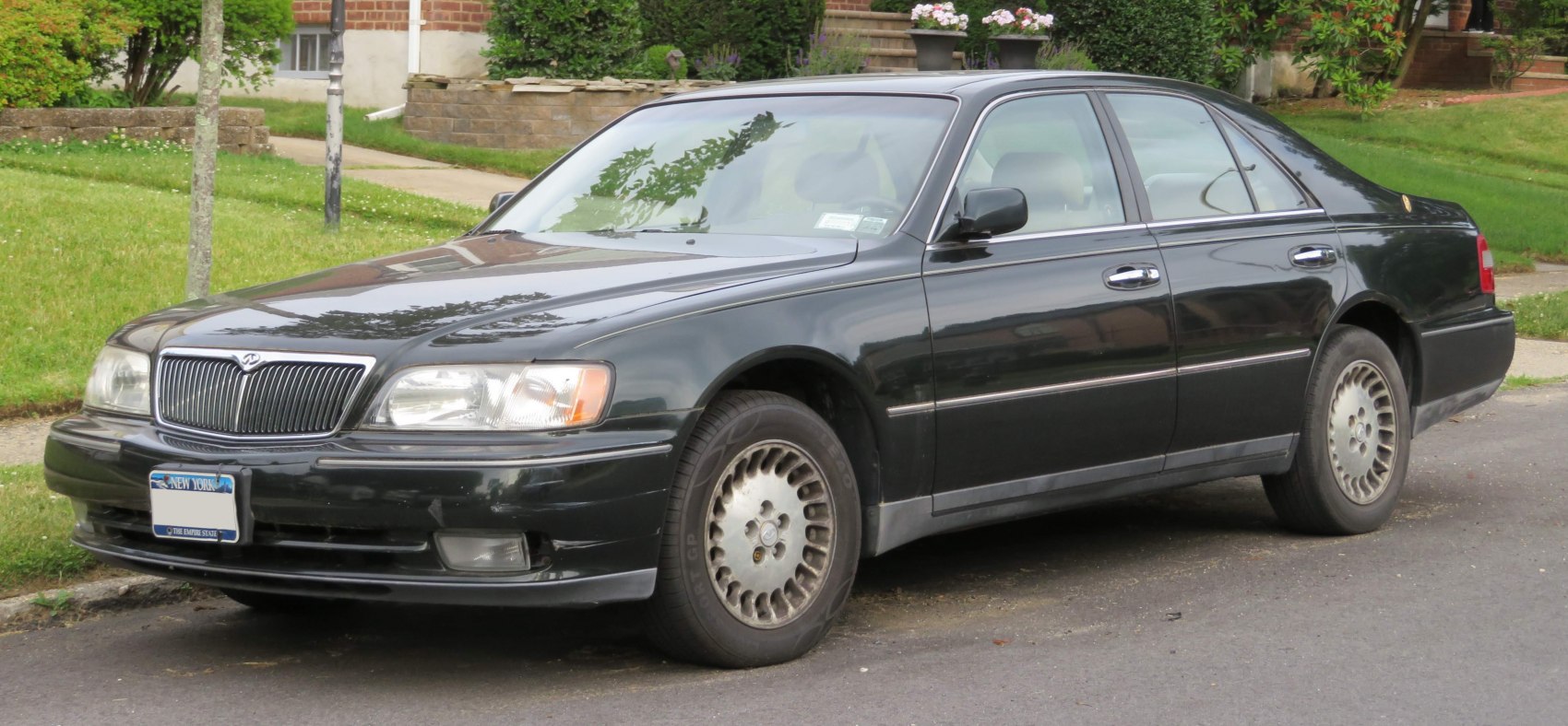 Luxury sedan with vertical slat grille and alloy wheels