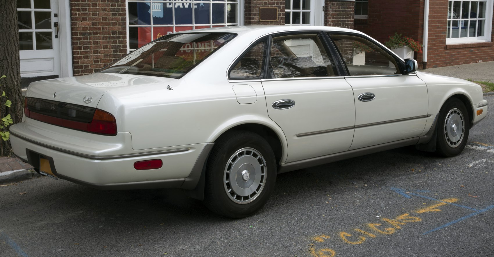 Rear and side angle of a mid-size sedan with vintage wheel covers and smooth lines