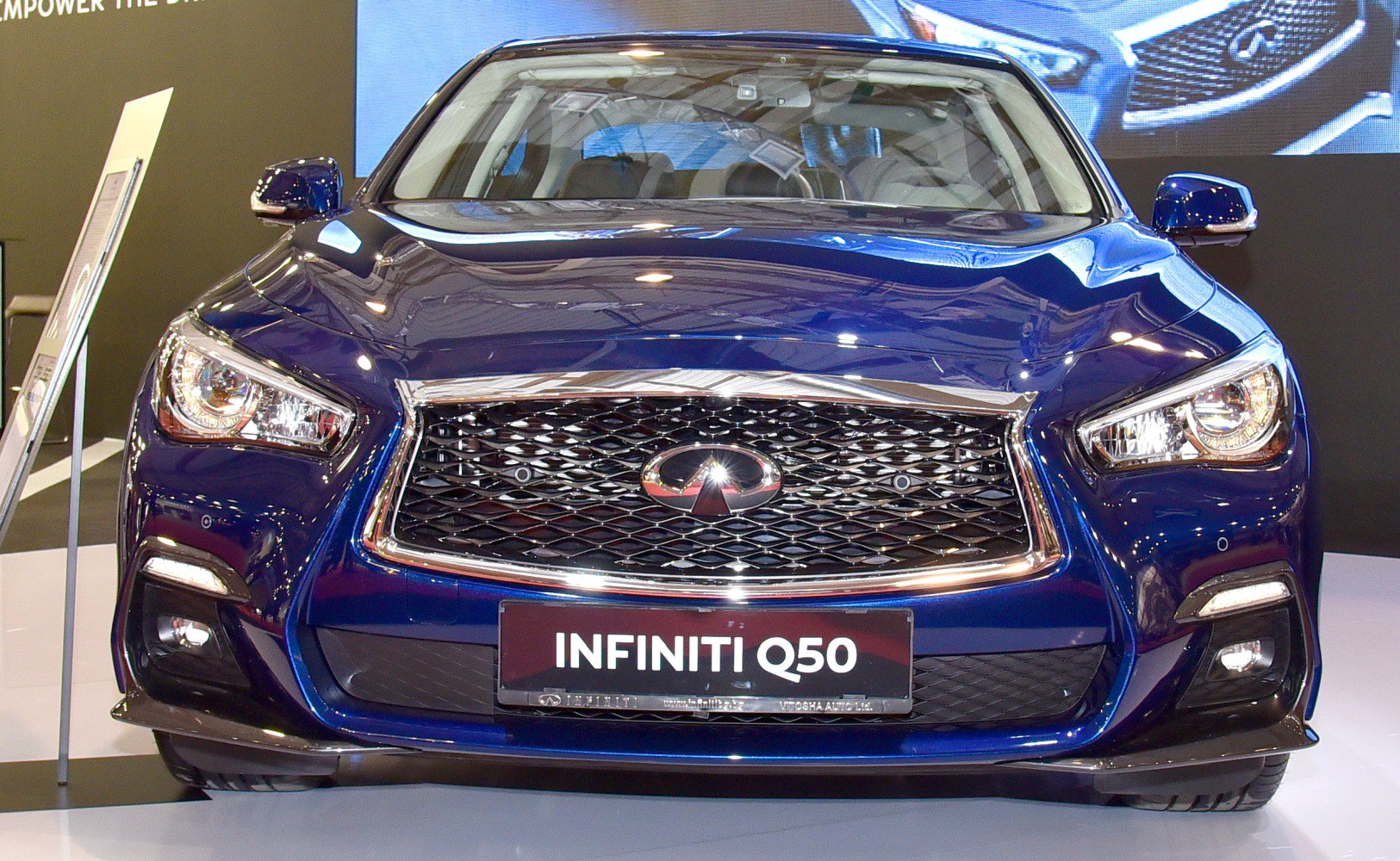 Close-up of Infiniti Q50 front grille and headlights with chrome details.