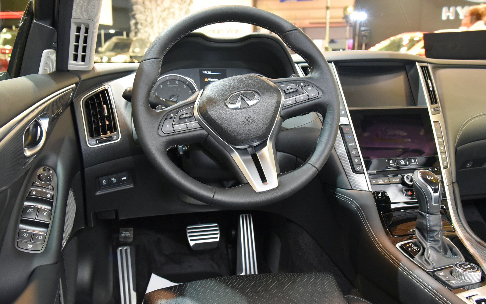 Steering wheel, digital dashboard, center console with gear shifter.