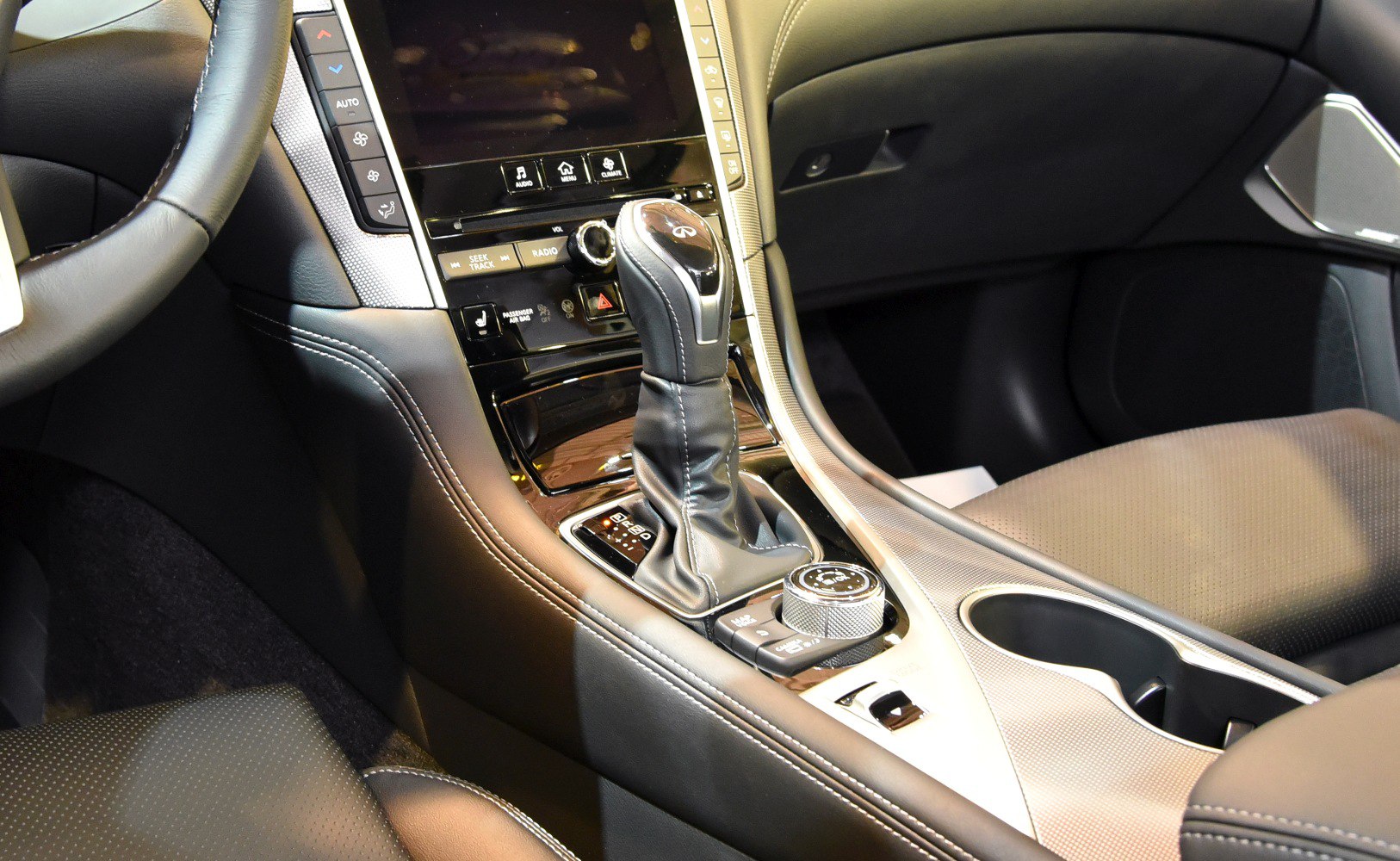 Close-up of gear shift lever and center console with control knob and buttons.