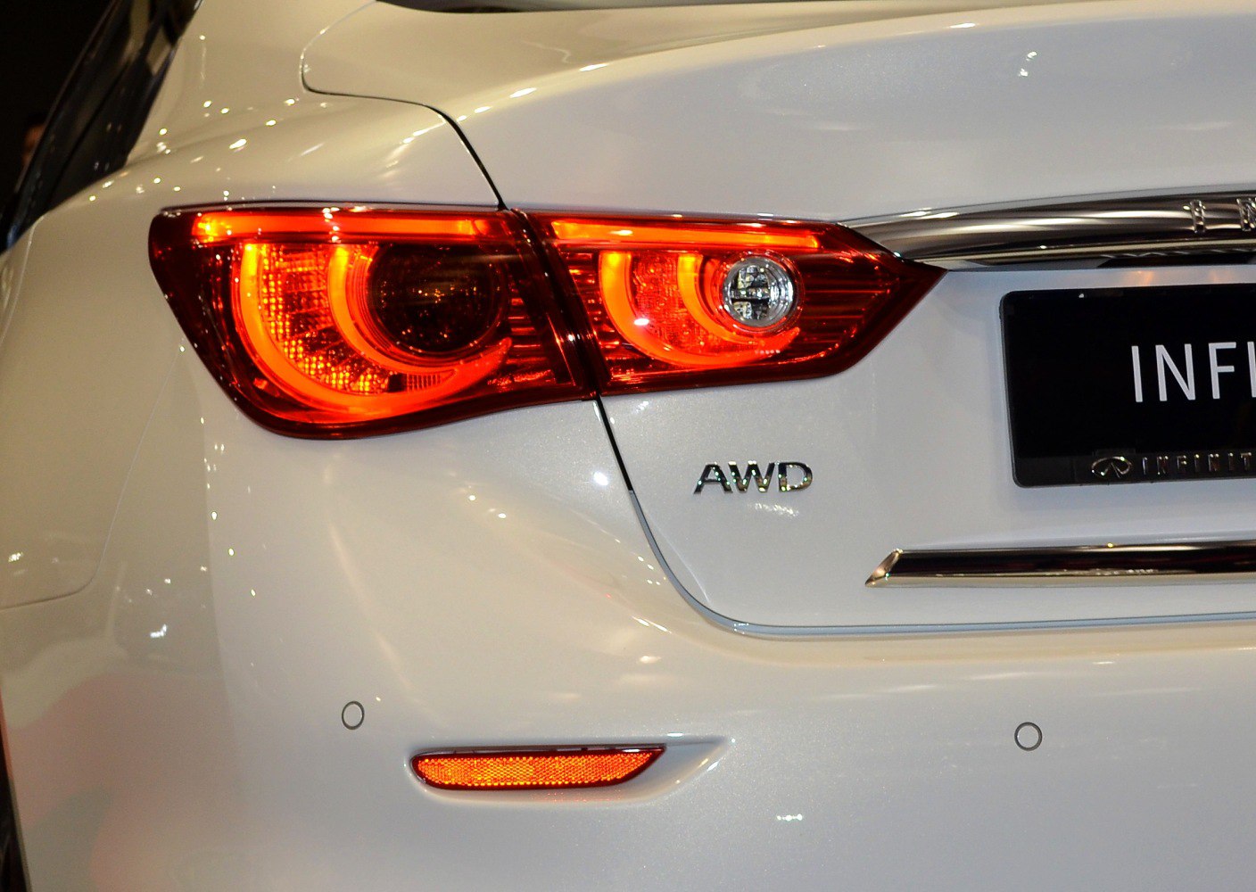 Close-up view of rear LED lights and AWD badge on white car rear