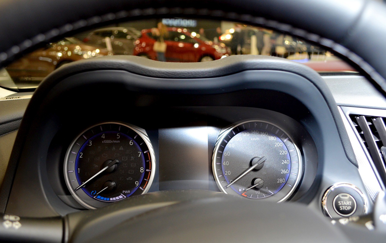 Dashboard instrument cluster with tachometer, speedometer, fuel gauge, and start stop button