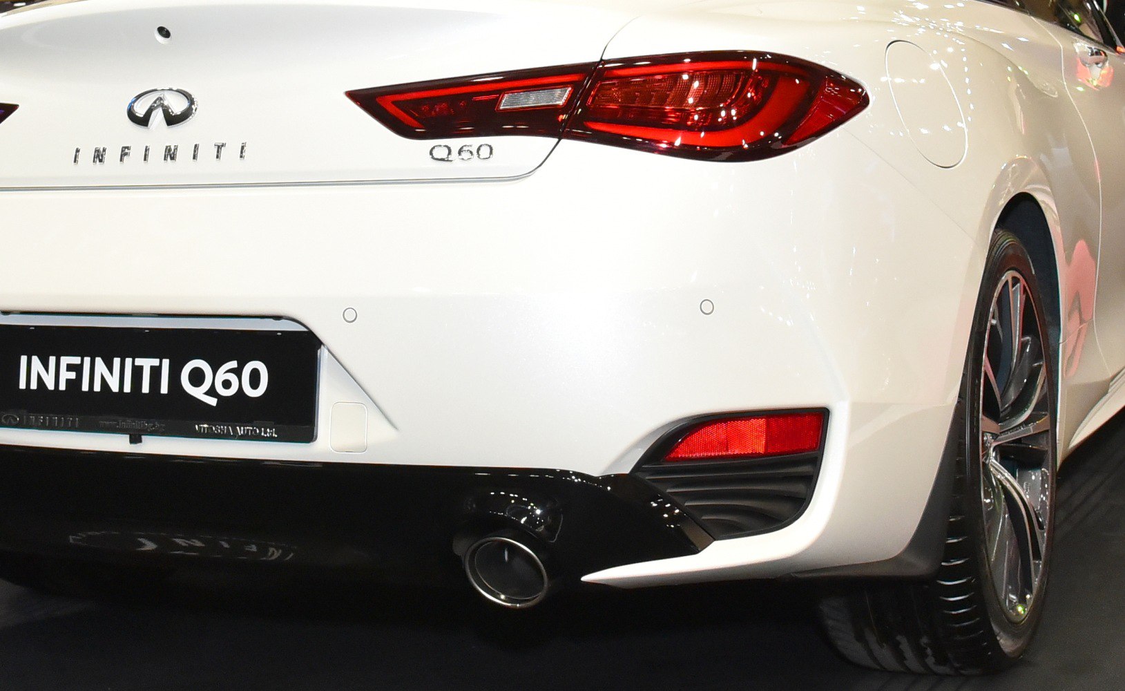 Car rear tail light, exhaust pipe, and alloy wheel close-up