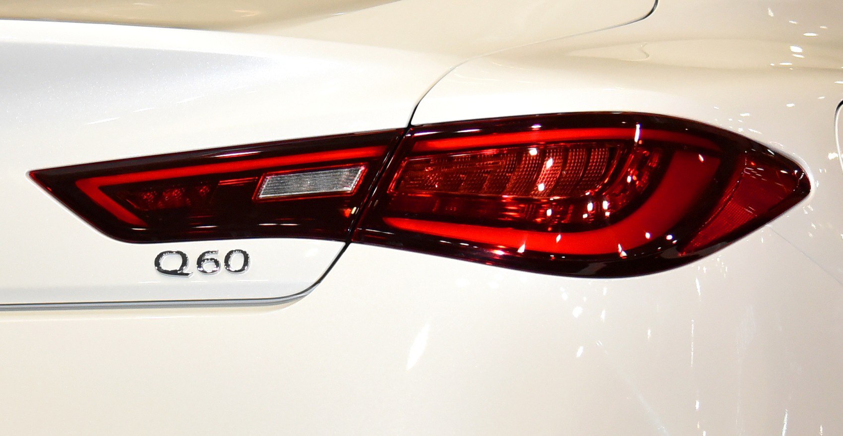 Rear tail light and Q60 badge on white car body