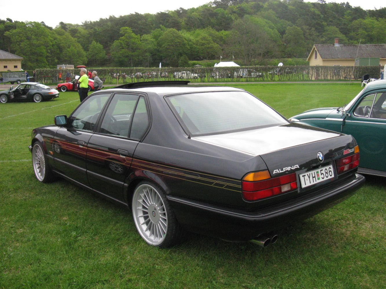 Black sedan with multi-spoke wheels, Alpina rear badge, and side stripes