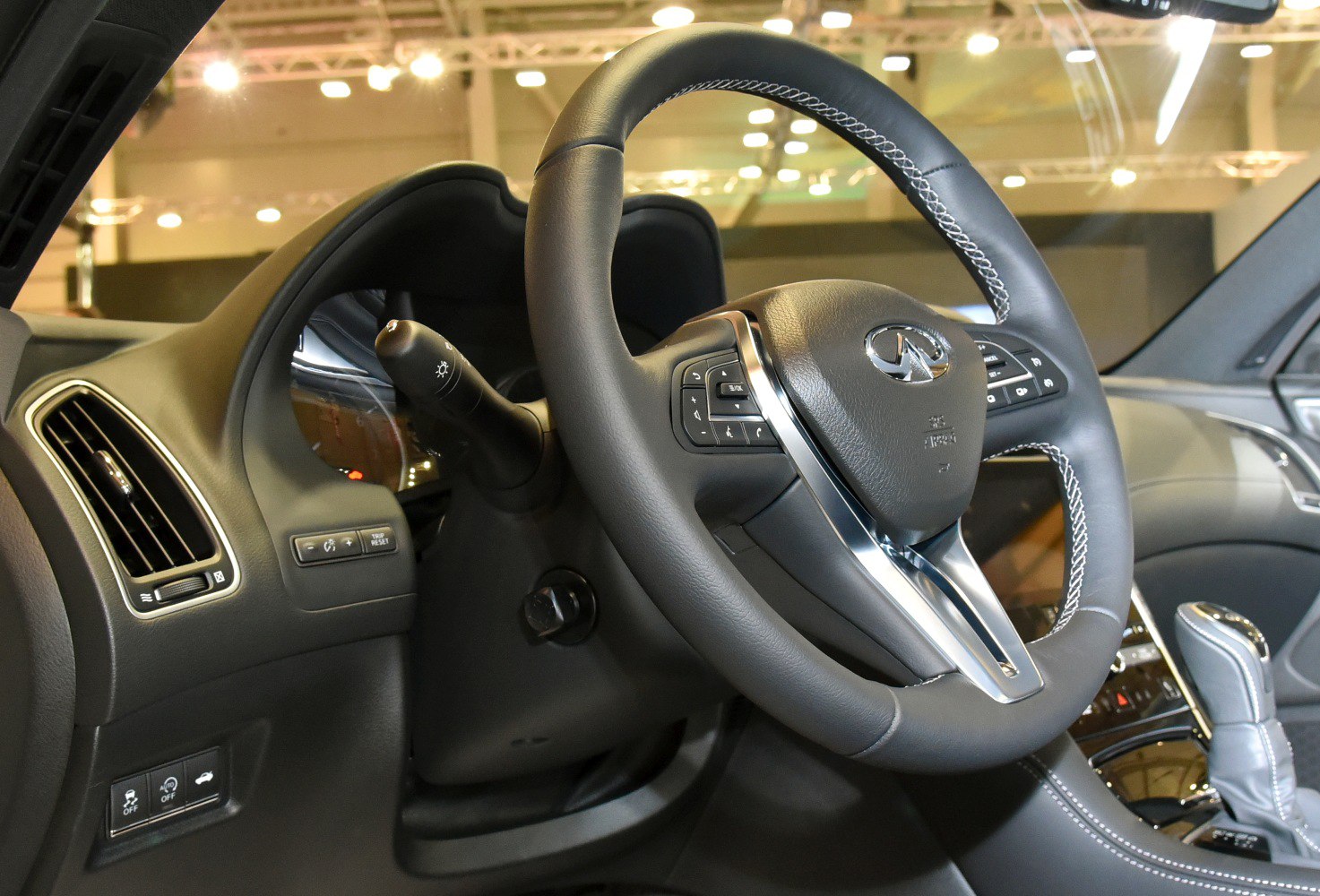 Close-up of steering wheel and dashboard with control buttons and gear shifter