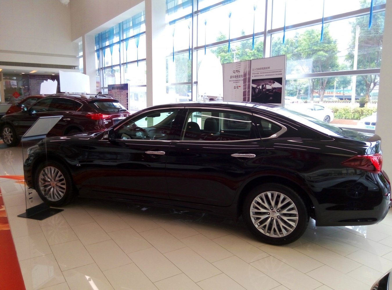 Luxury sedan side profile with alloy wheels in showroom