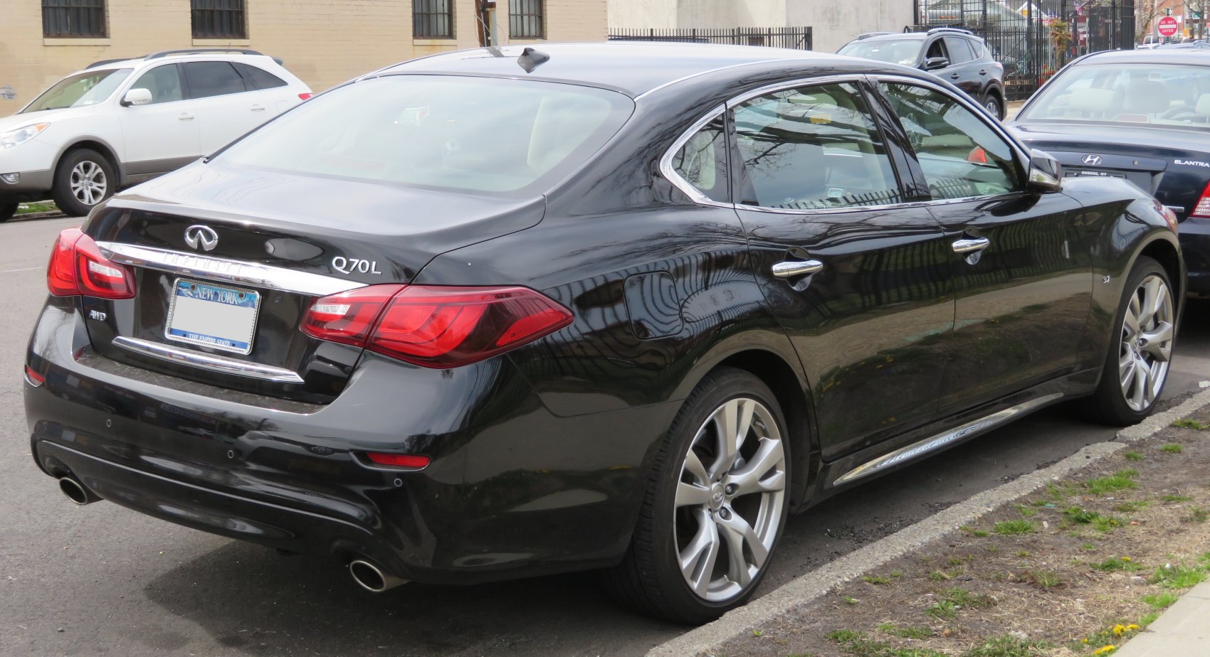 Rear three-quarter view of black luxury sedan with dual exhaust and distinct taillights