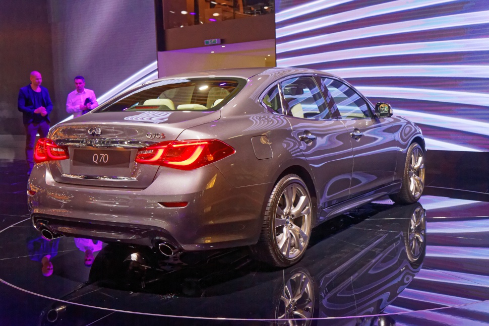 Rear view of luxury sedan with illuminated taillights and dual exhausts