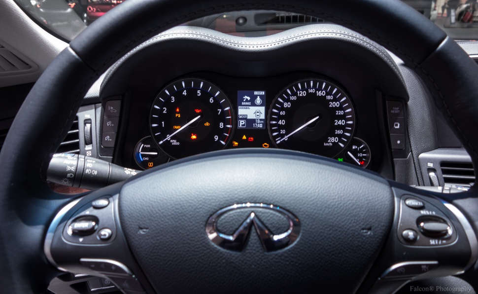 Instrument cluster and steering wheel with control buttons and illuminated dashboard indicators.