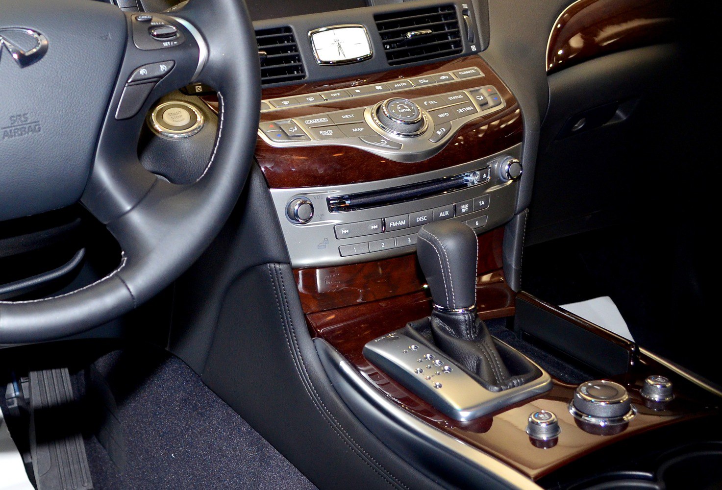 Wood-accented luxury center console with automatic gear shift and multimedia controls