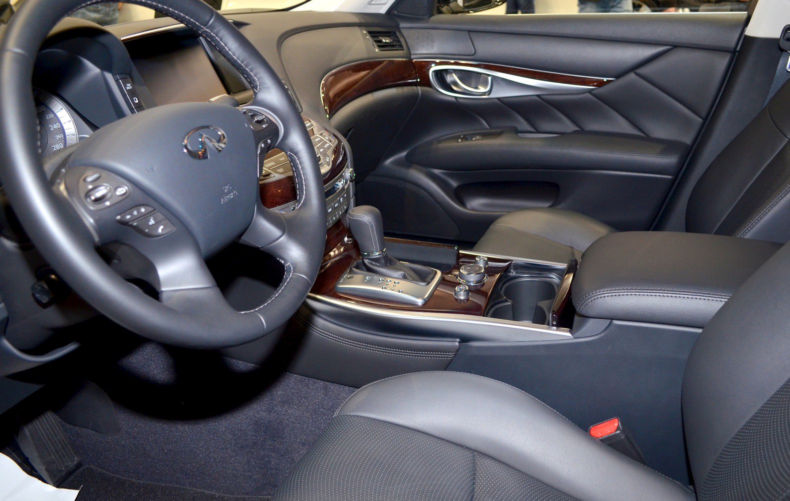 Luxury car interior with leather seats, wood trim, and advanced dashboard controls