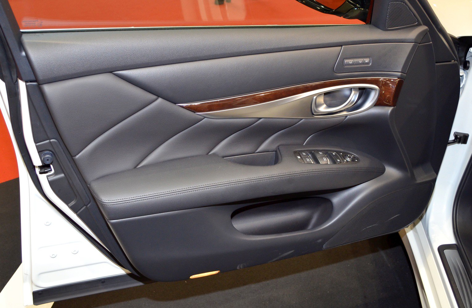 Luxury car door panel with wood trim and metal handle
