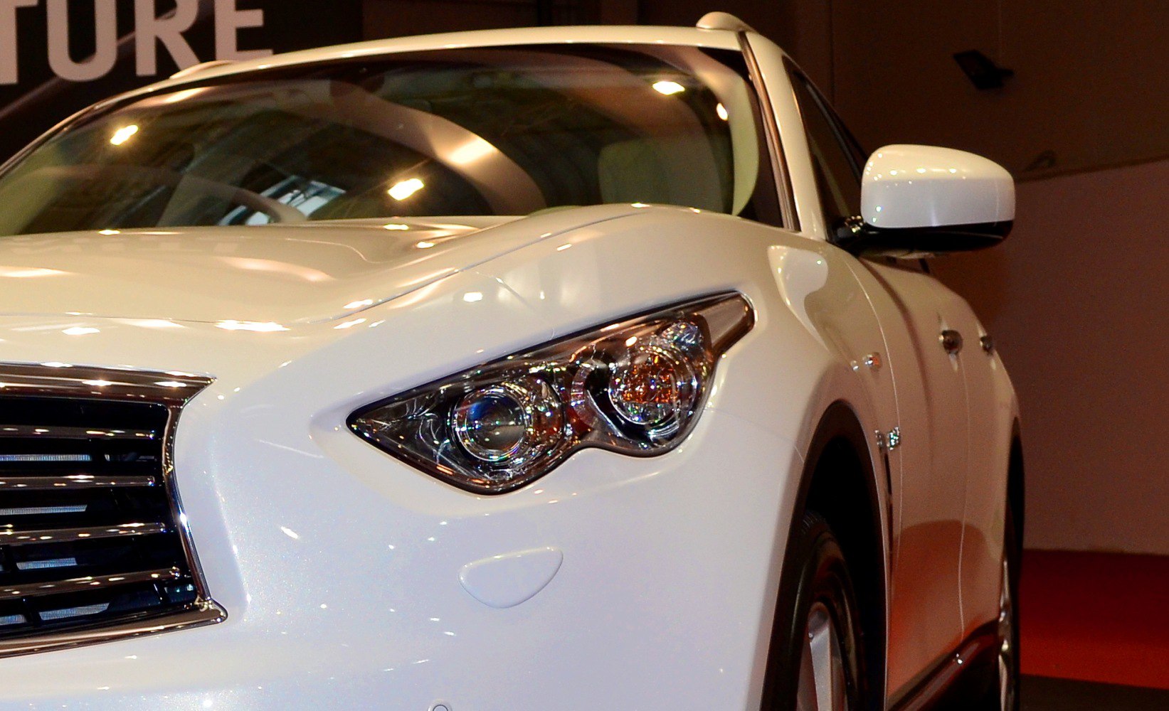 Close-up of car headlight and front grille with sleek design.