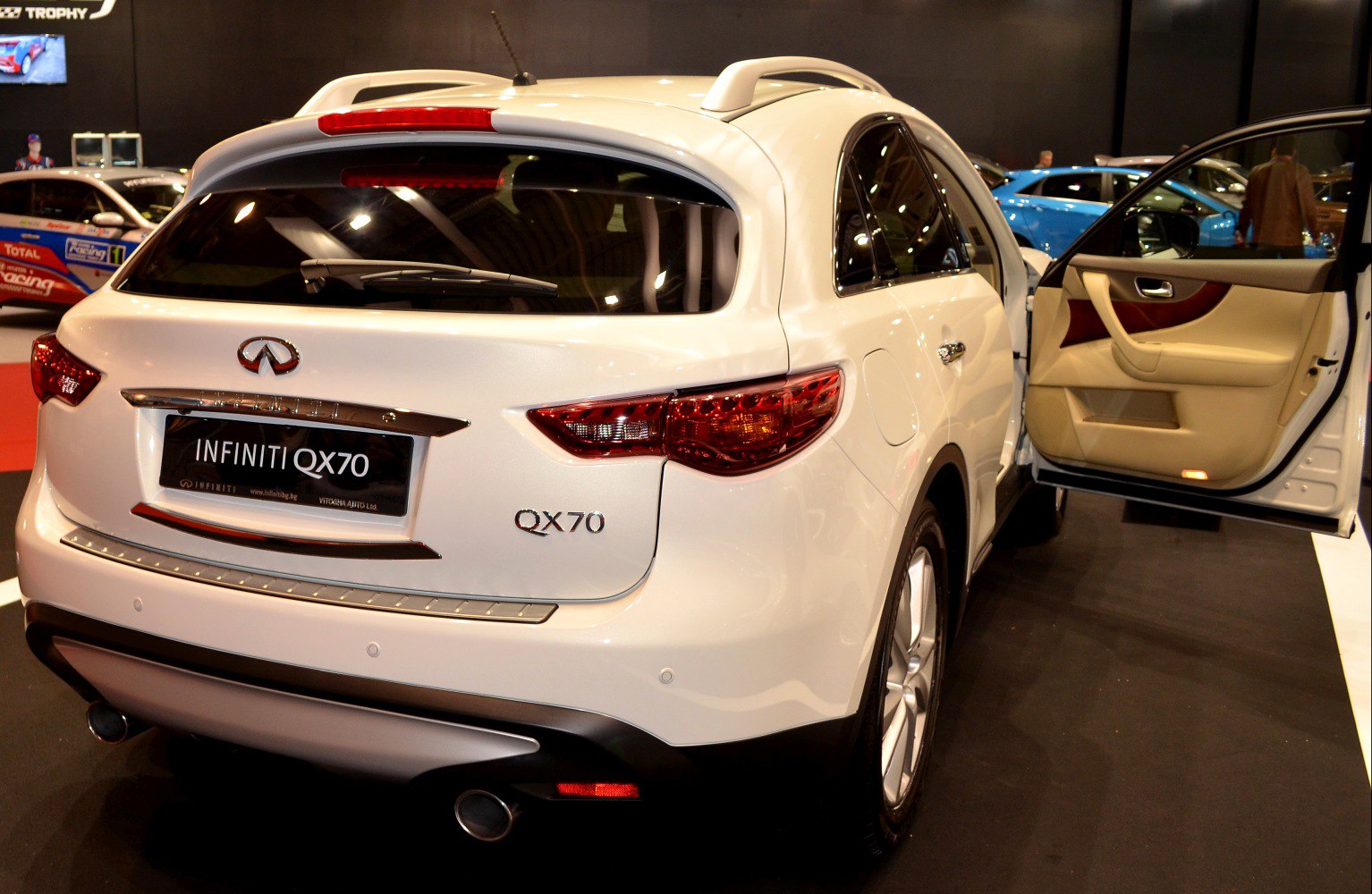 Rear view of SUV with open driver's door showing beige leather interior