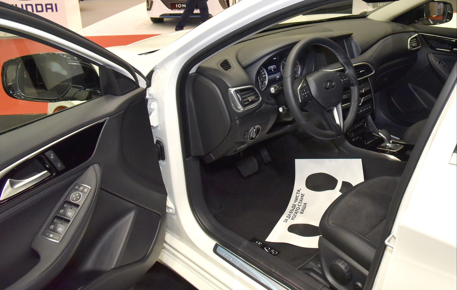 Driver side dashboard, steering wheel, and door panel controls in car interior