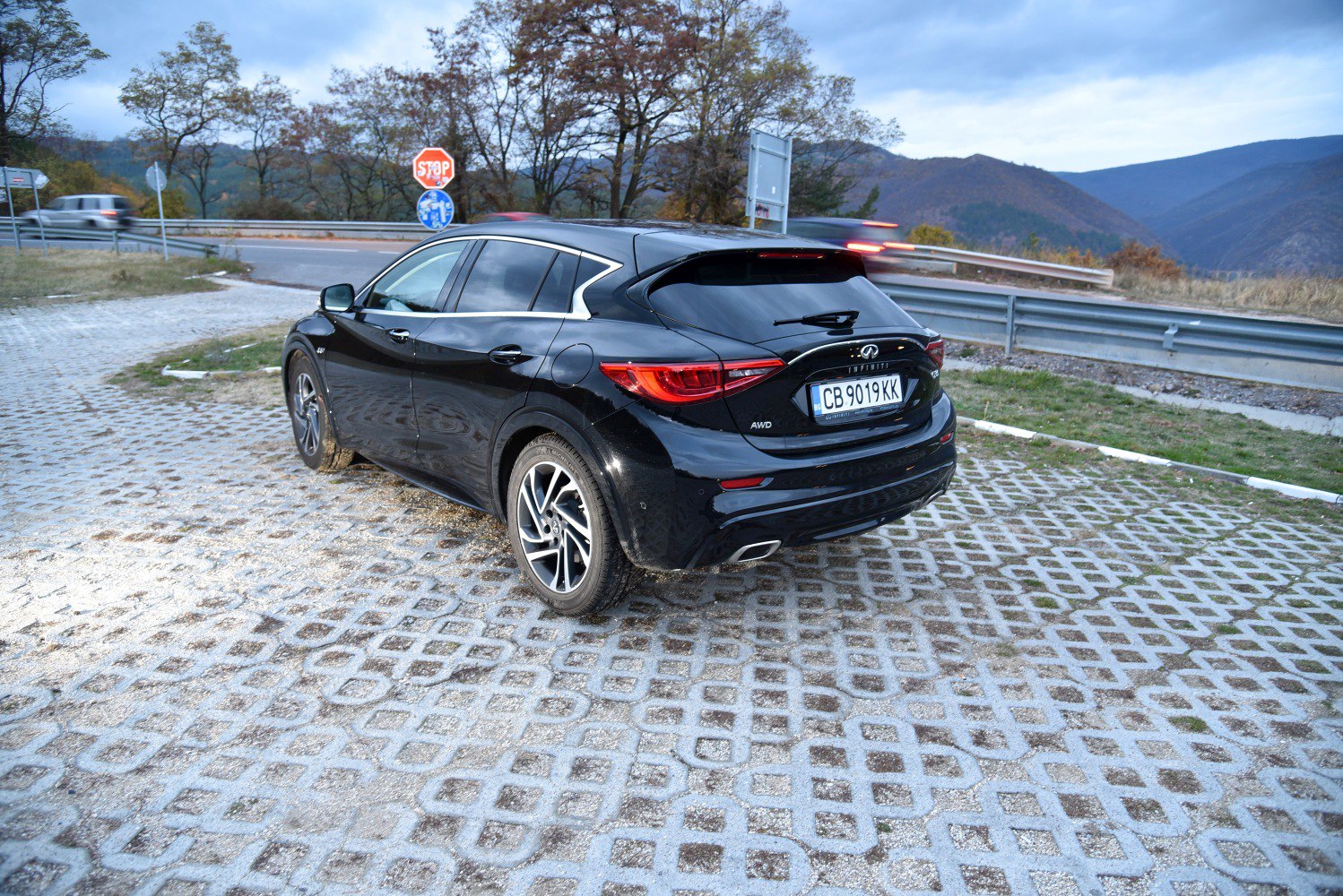 Black liftback with alloy wheels at roadside in mountainous autumn setting