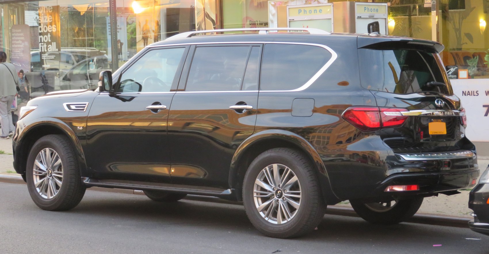 Black large luxury SUV showing side profile and rear details with tinted windows.