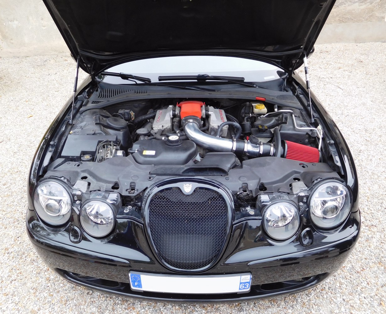 Open hood showing engine bay with cold air intake and quad headlamps