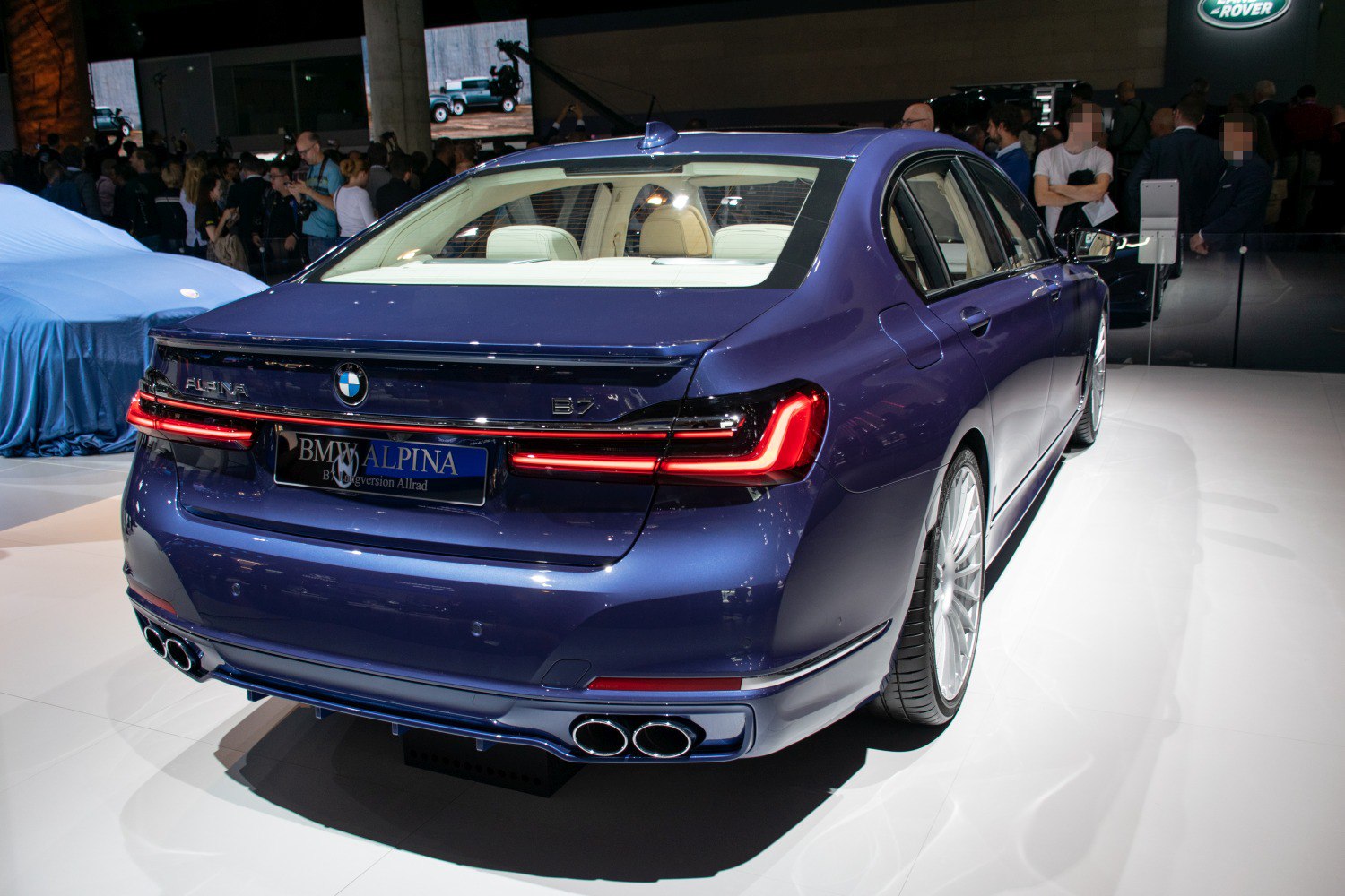 Luxury sedan rear with quad exhausts and sleek taillights