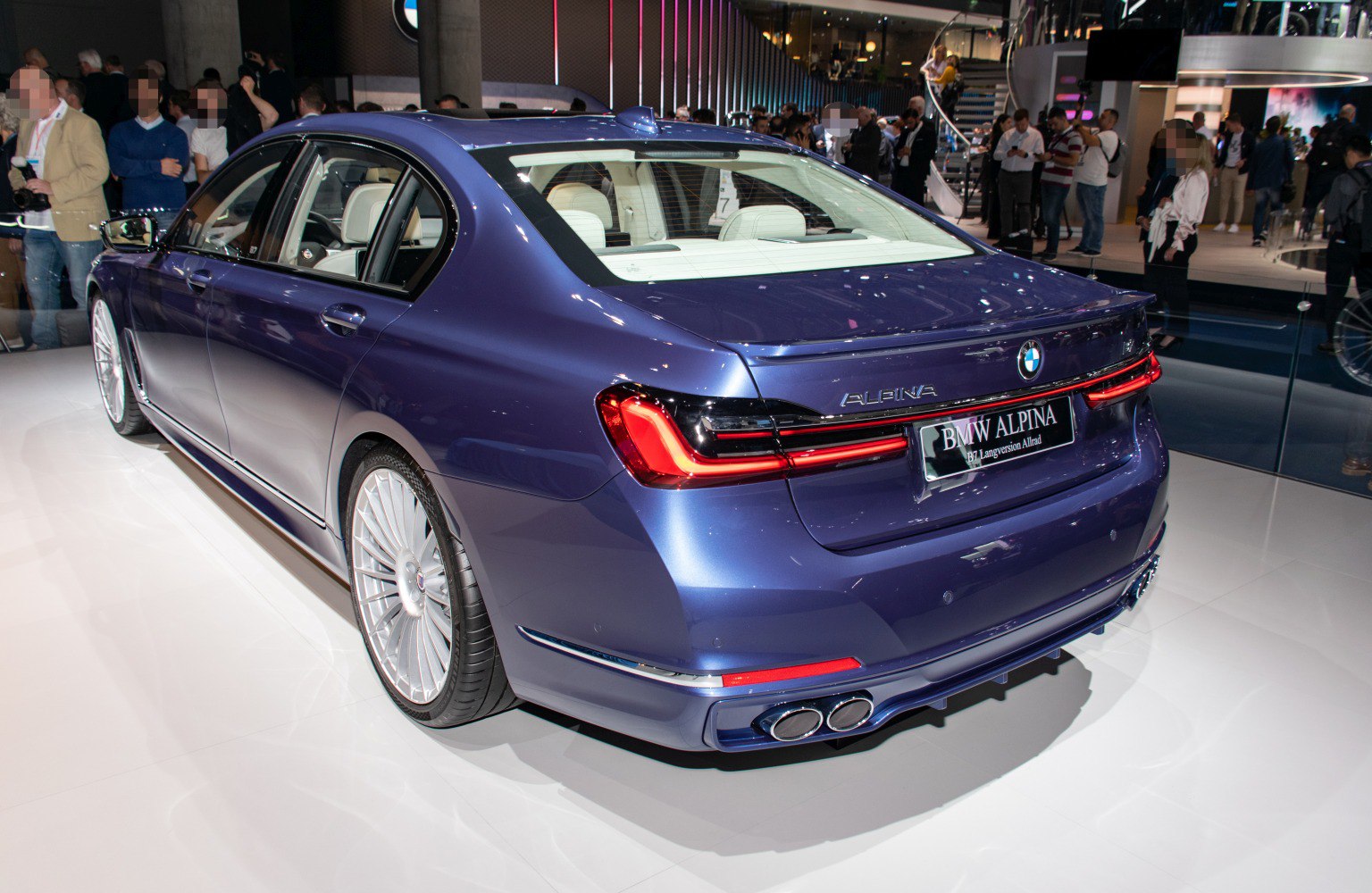 Rear and side view of luxury sedan with quad exhausts and sleek taillights