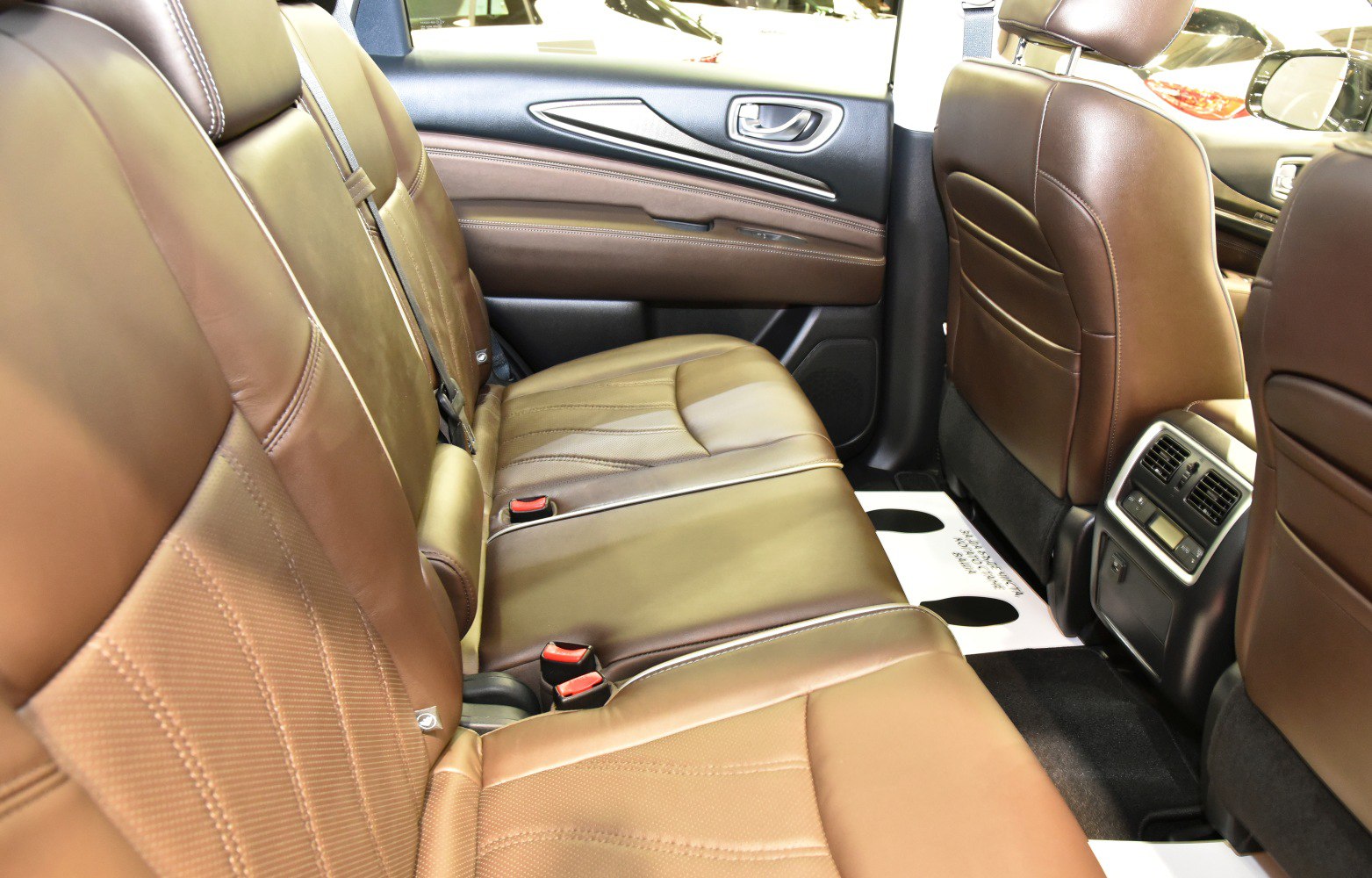 Brown leather rear seats with air vents and seatbelt buckles