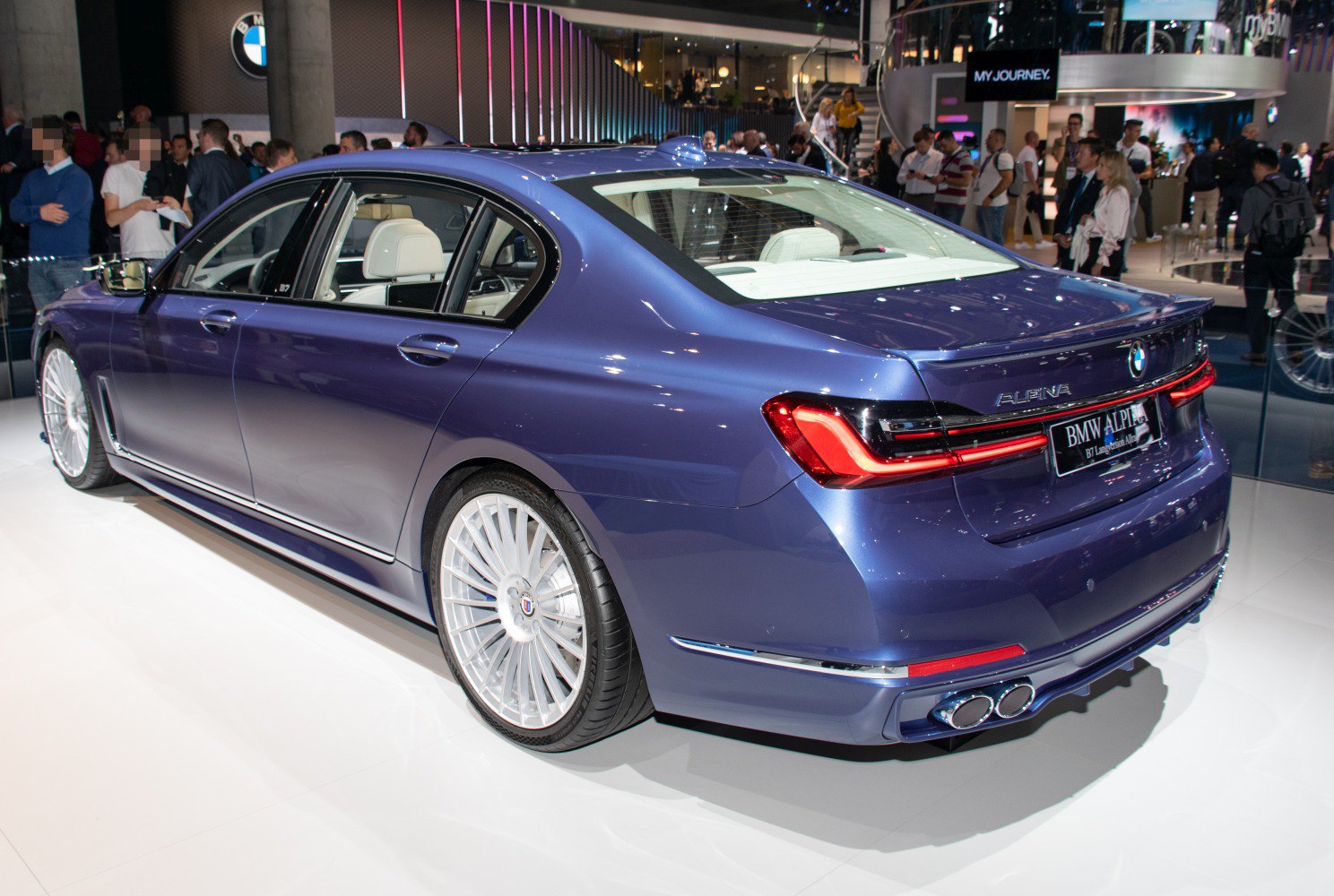 Luxury sedan rear with quad exhausts and multi-spoke alloy wheels