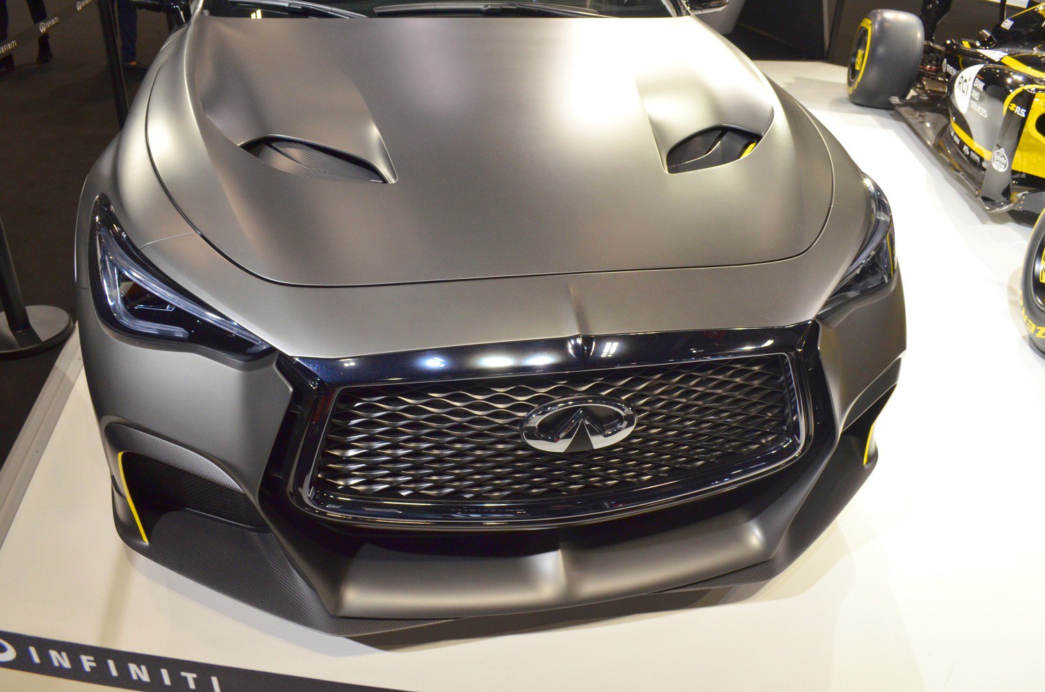 Close-up of a vented hood and aggressive front grille with LED headlights