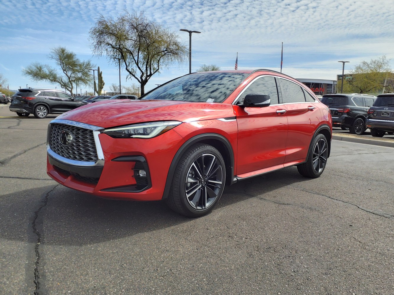 Front side view of sleek red SUV with bold grille and alloy wheels