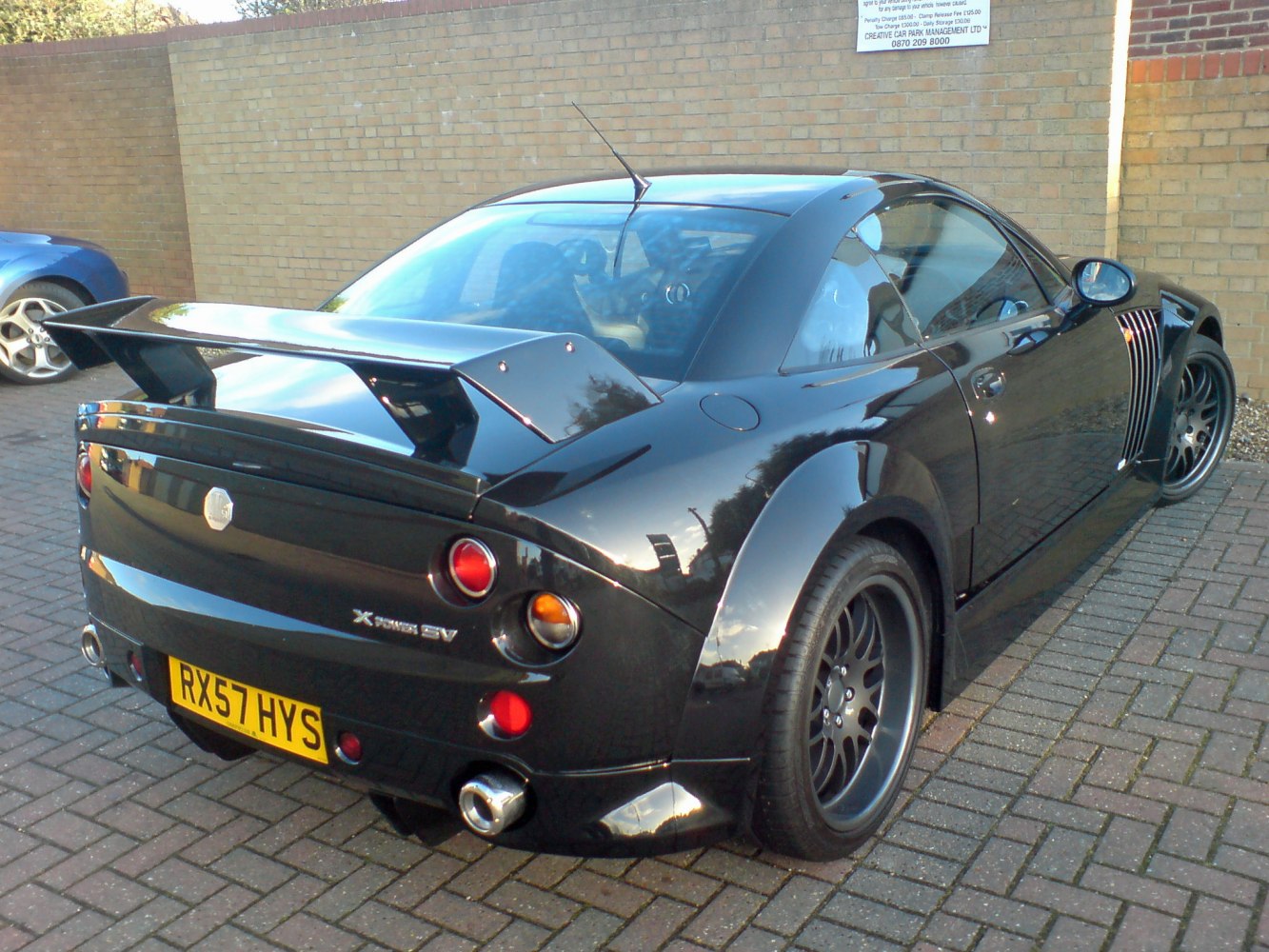 Large rear spoiler, round tail lights, dual exhaust, wide rear tires