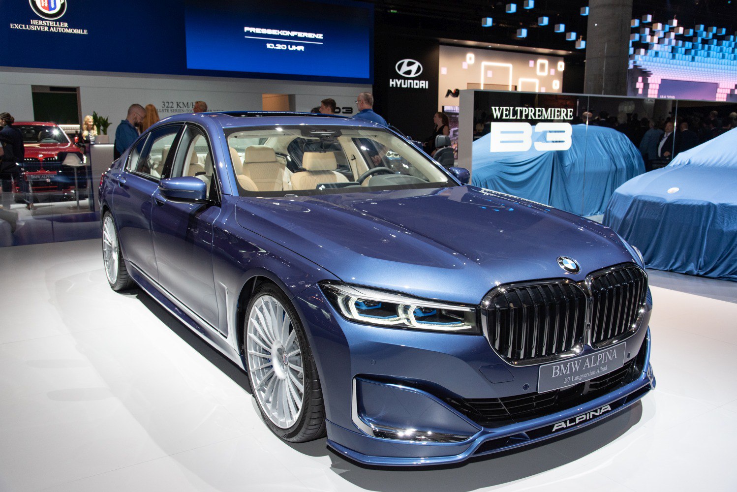 Luxury sedan front-side view with signature grille and multi-spoke wheels
