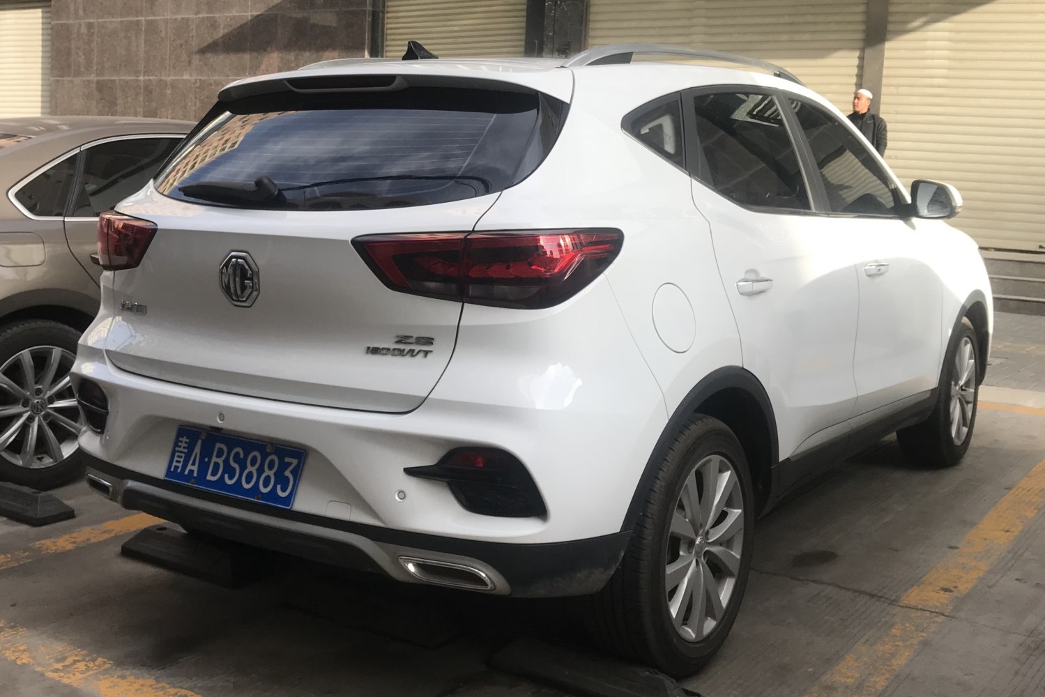 Rear side of white SUV with LED taillights and dual exhaust outlets