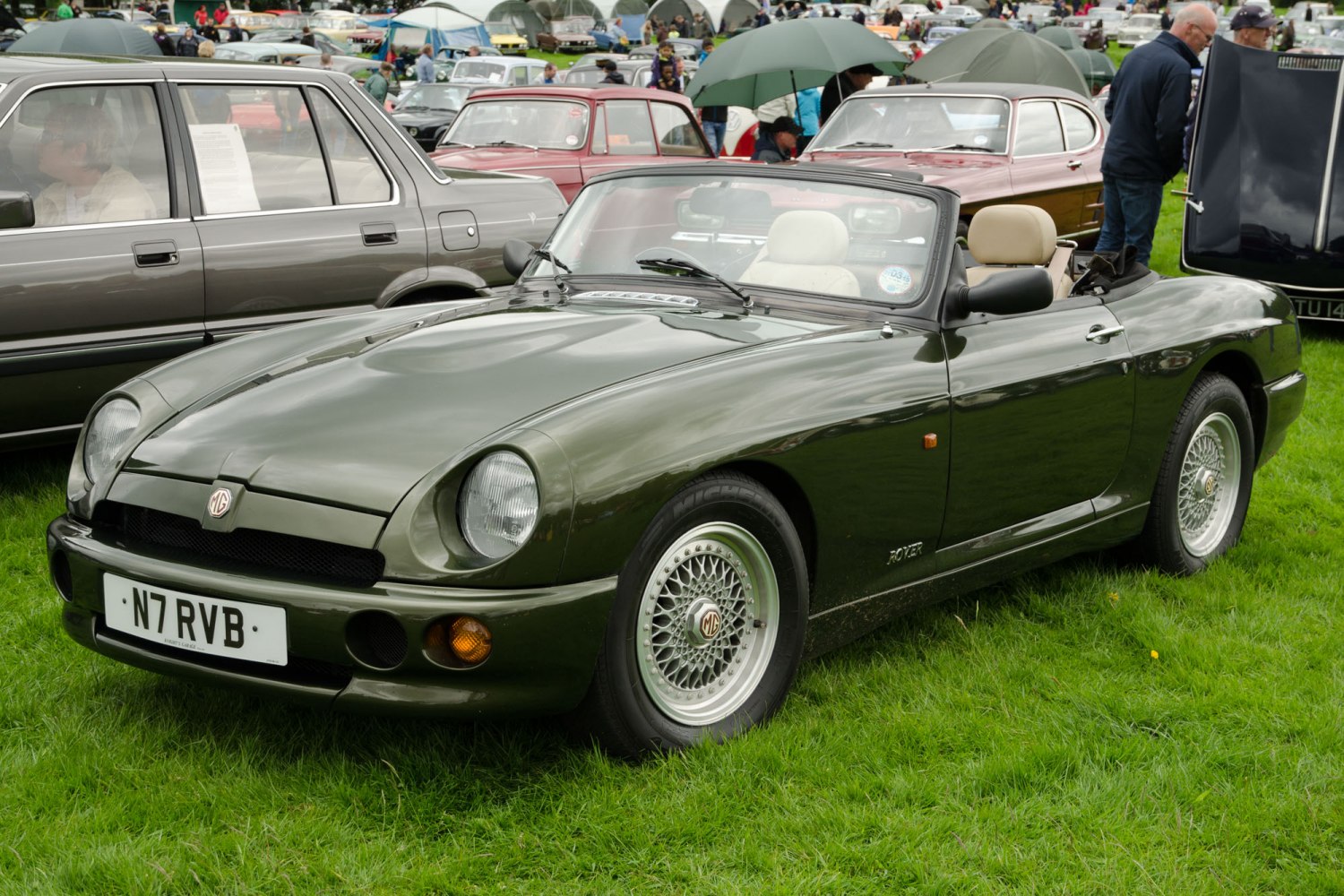 Green classic convertible roadster with wire wheels and distinctive rounded headlights