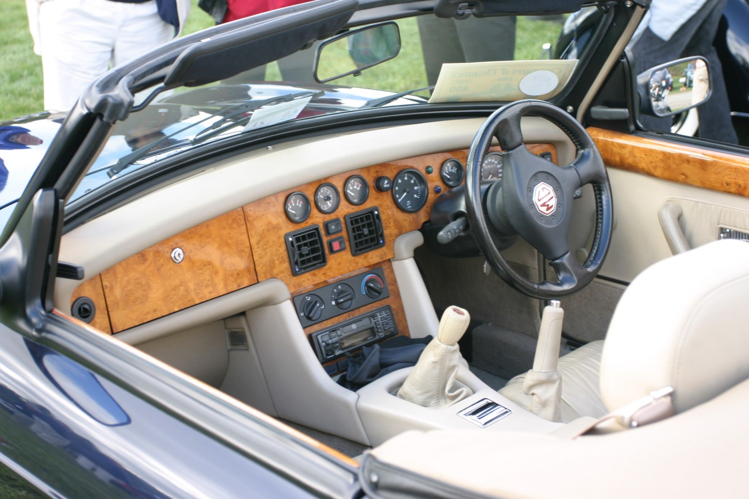 Wooden dashboard, analog gauges, leather seats, manual gearbox in convertible interior