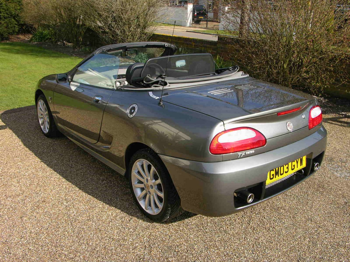 Rear view of convertible with soft top down and sporty rear design