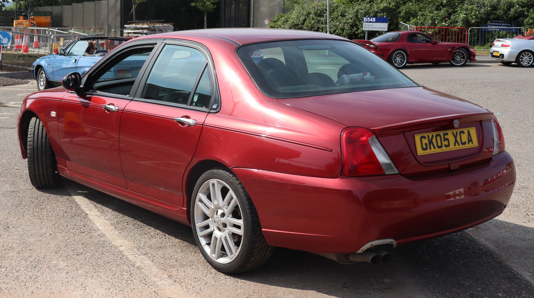 Rear side view of a sedan with alloy wheels and dual exhaust.
