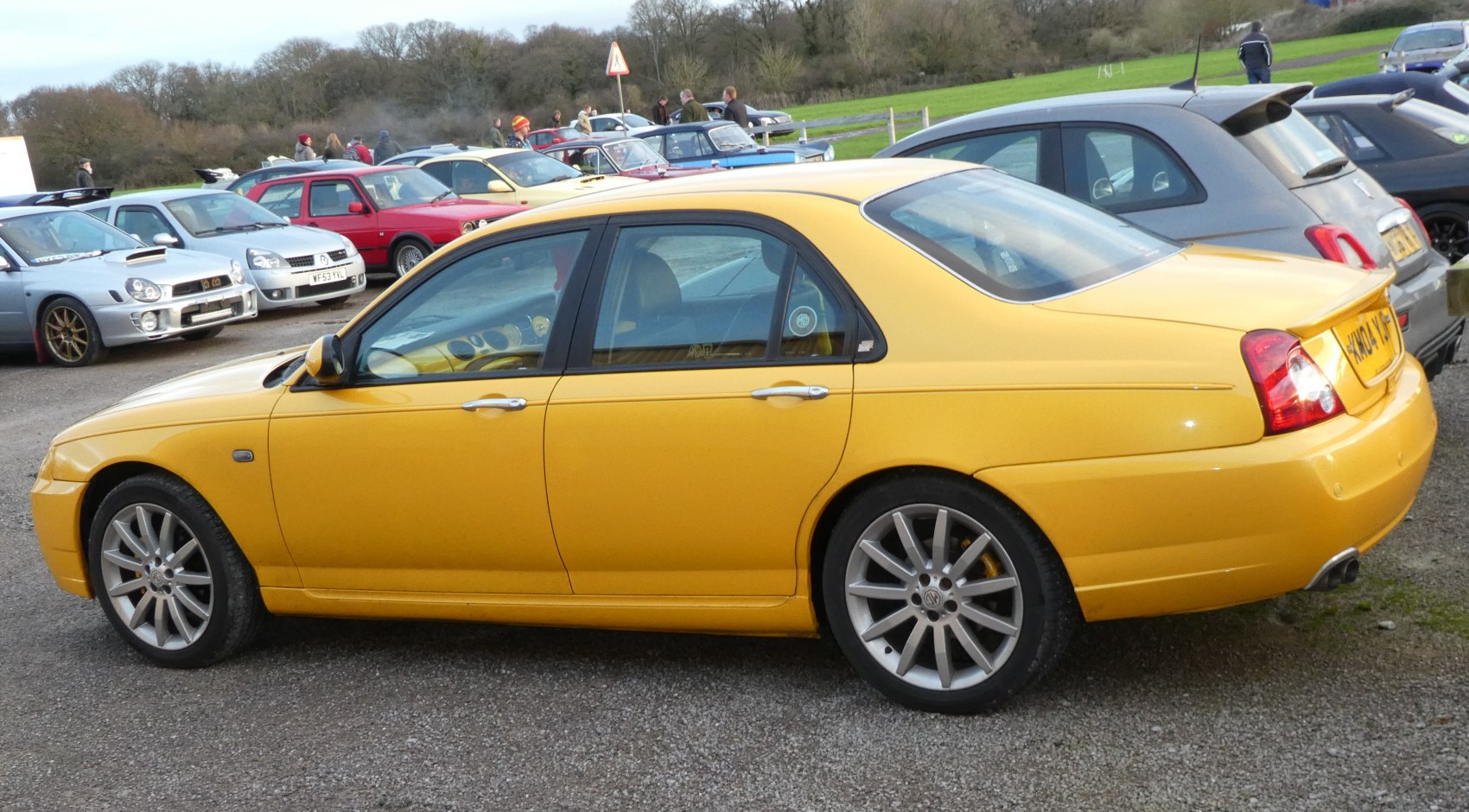 Yellow sedan side view with alloy wheels and sporty design