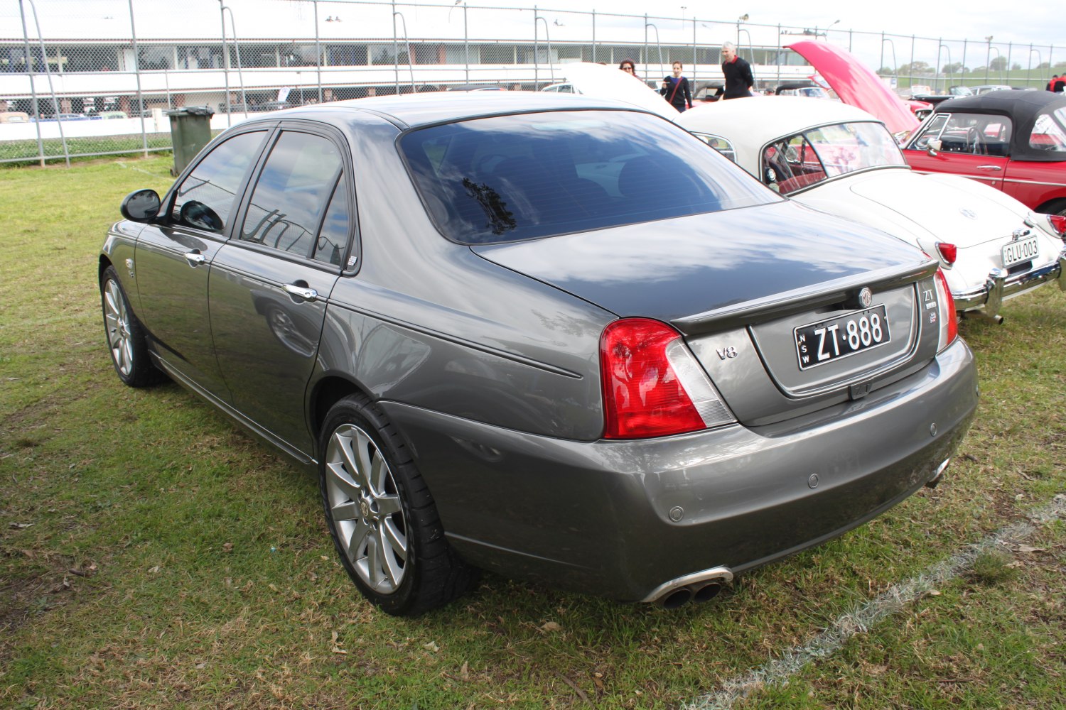 Rear and side view of a tinted window sedan with V8 badge and alloy wheels