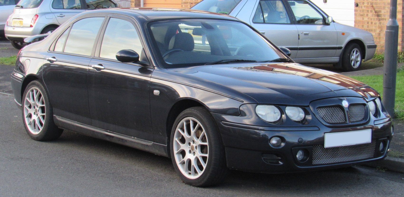Close-up of front grille and alloy wheels on a sedan.