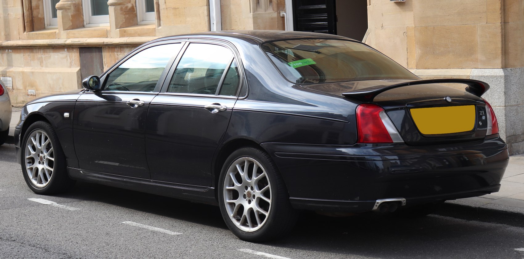 Black sedan with rear spoiler and multi-spoke alloy wheels